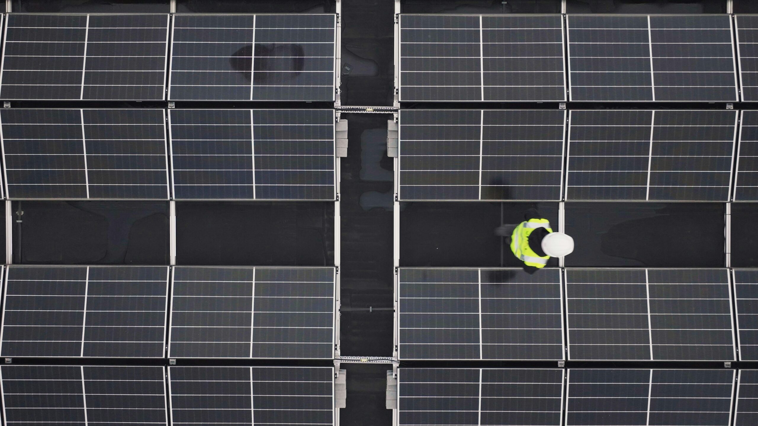 Solar carports being installed in a sunny, arid coastal environment near a water treatment facility.