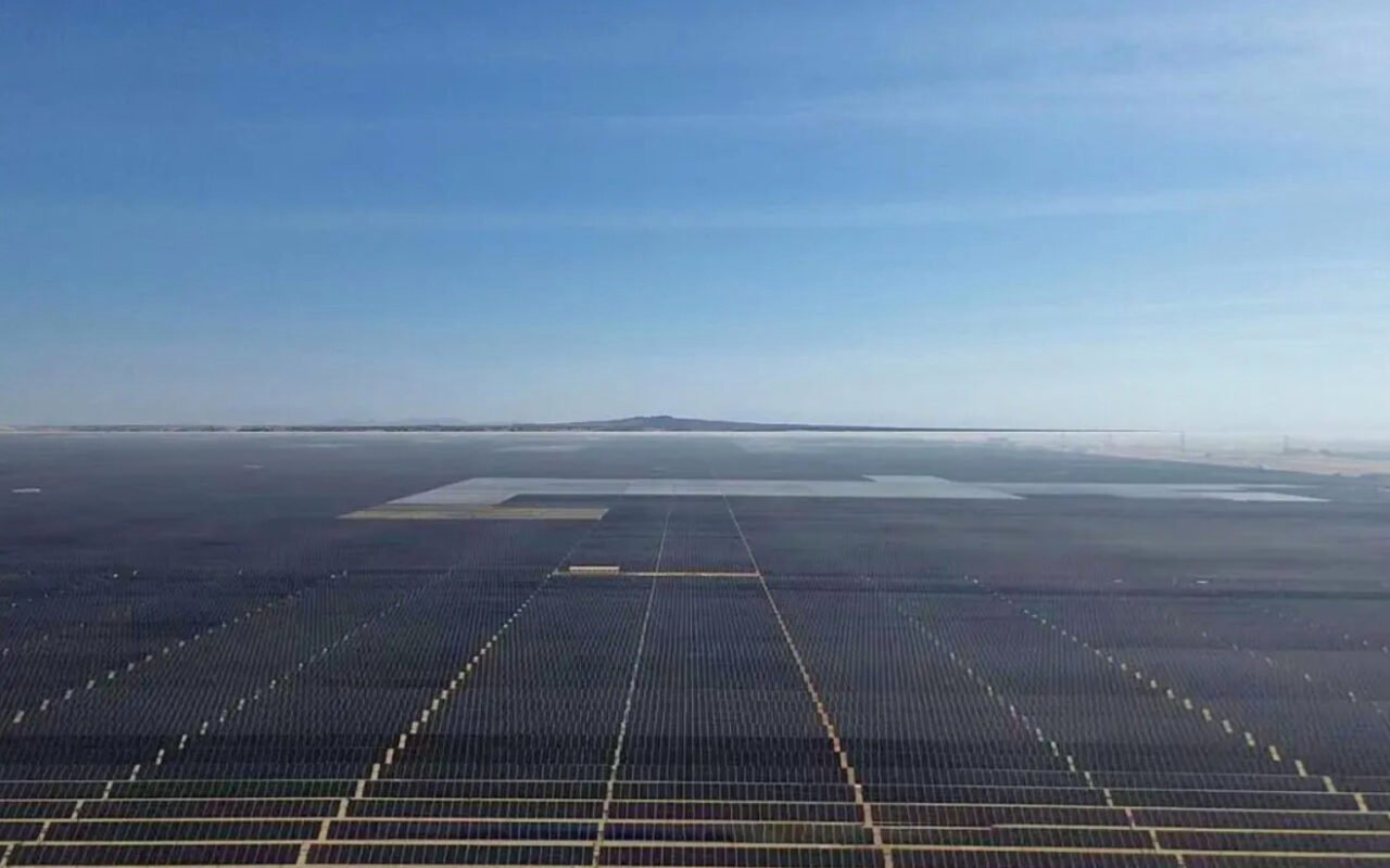 A graph showing steep global solar capacity growth, overlaid on a solar panel array.