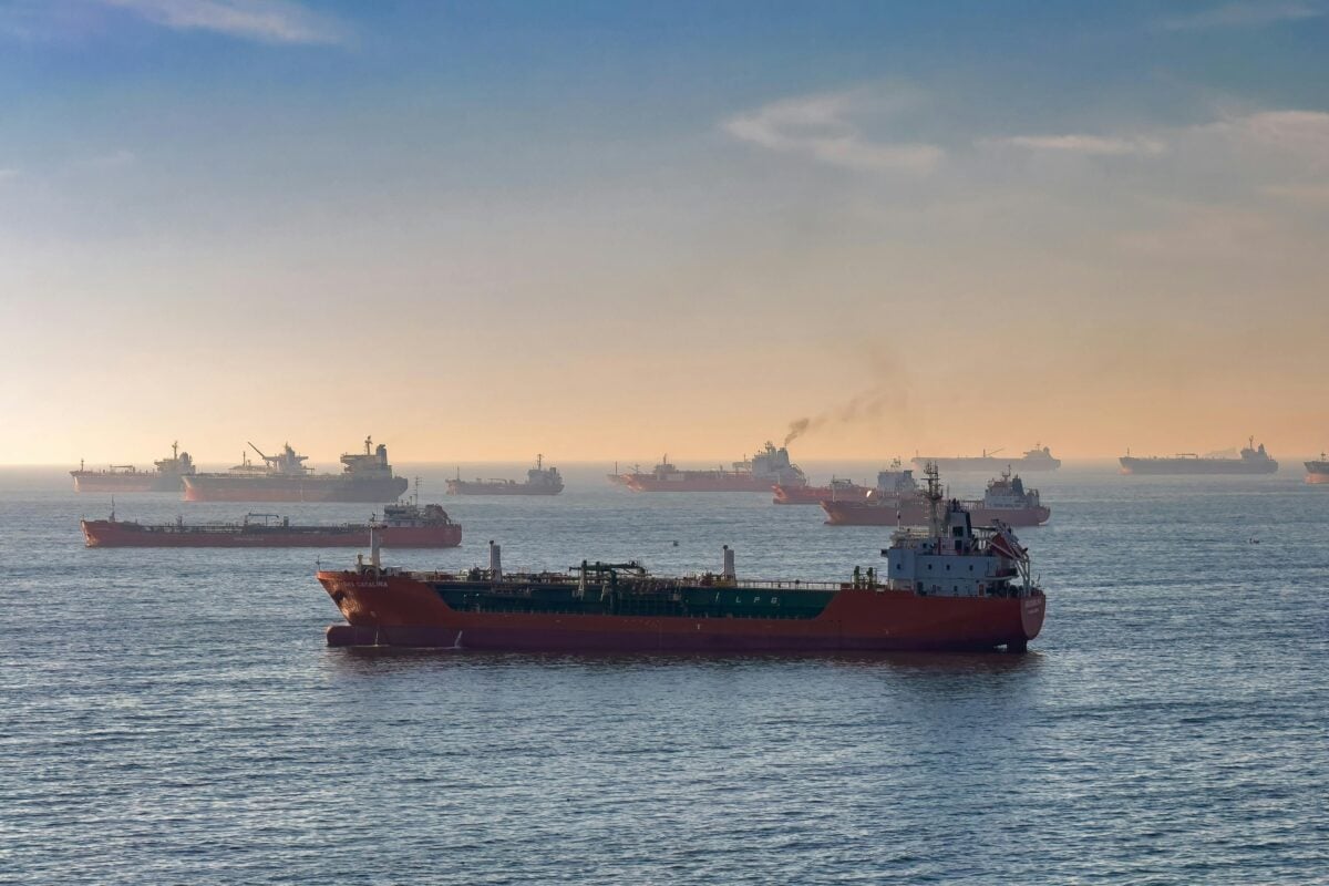 Container ship navigating rough waters representing supply chain disruption for battery storage systems.