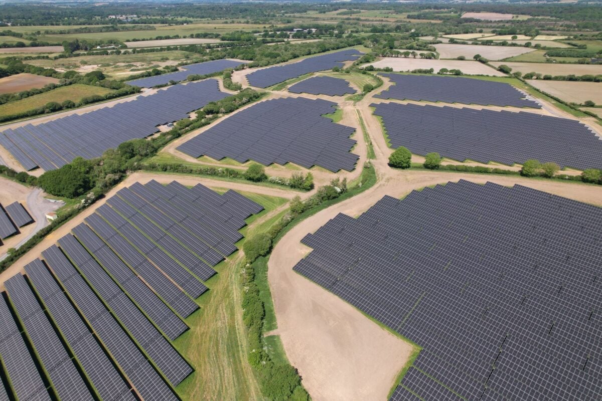 A modern solar farm with integrated utility-scale lithium-ion battery storage containers.