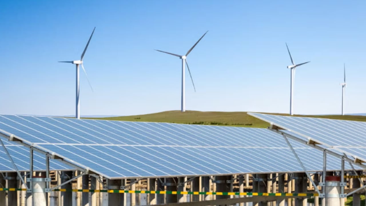A rows of white battery storage containers situated next to a large-scale photovoltaic array.