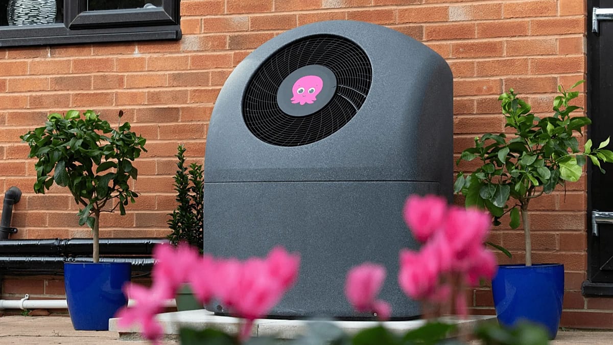 A modern heat pump installation next to a residential solar array on a roof