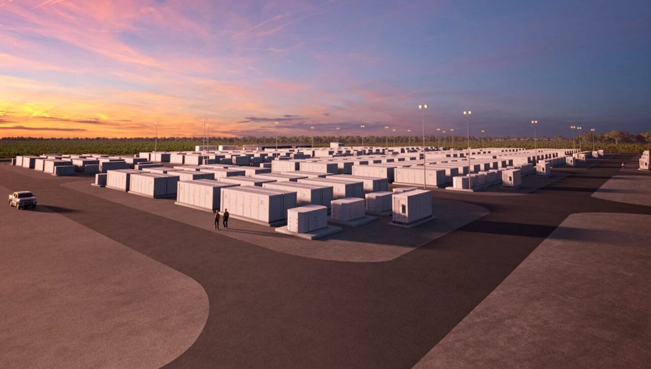 Aerial view of a large-scale lithium-ion battery energy storage system with white containers and electrical transformers.