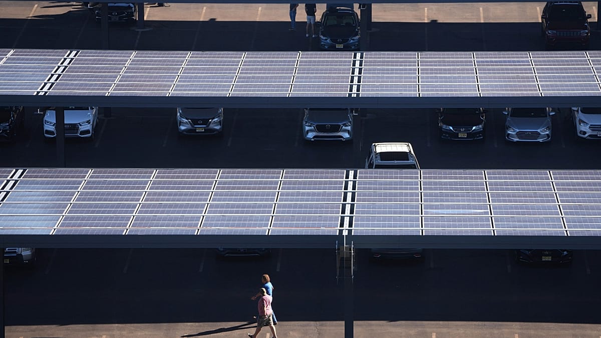 A modern solar farm in rural Europe integrated with containerized battery storage units under a clear sky.