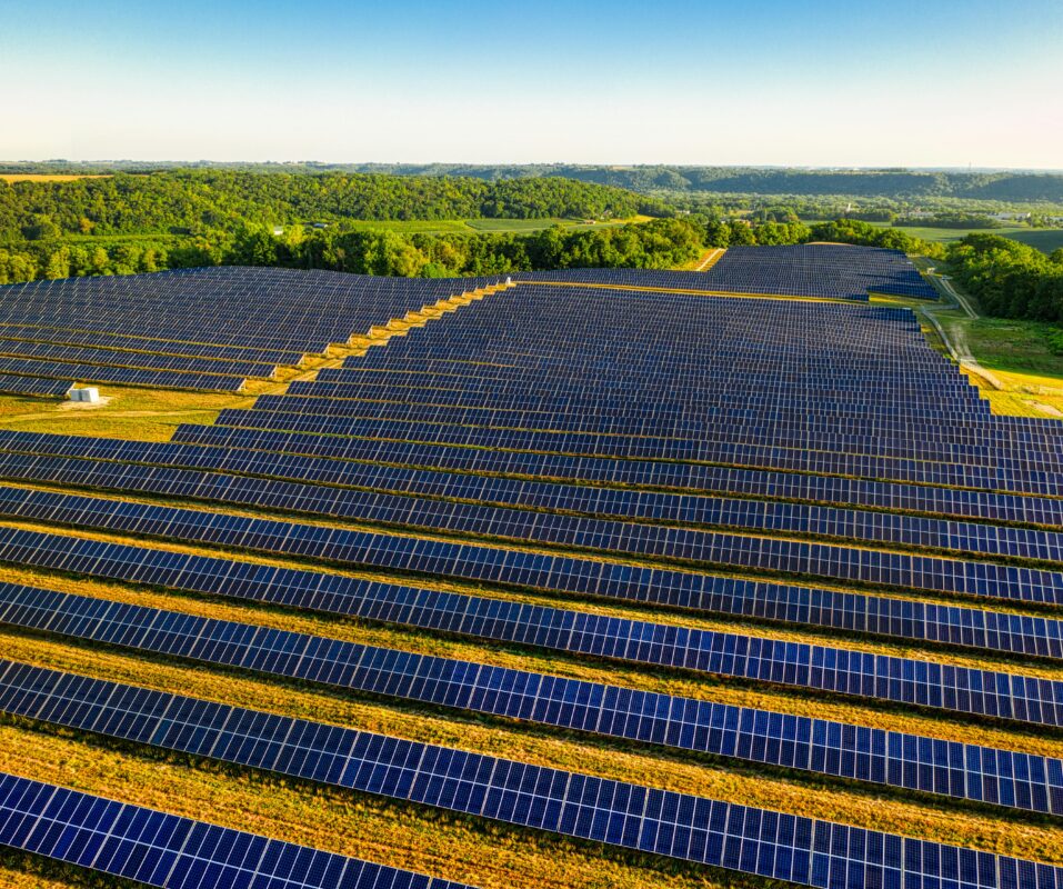 Aerial view of a large-scale solar farm under construction in a rural landscape