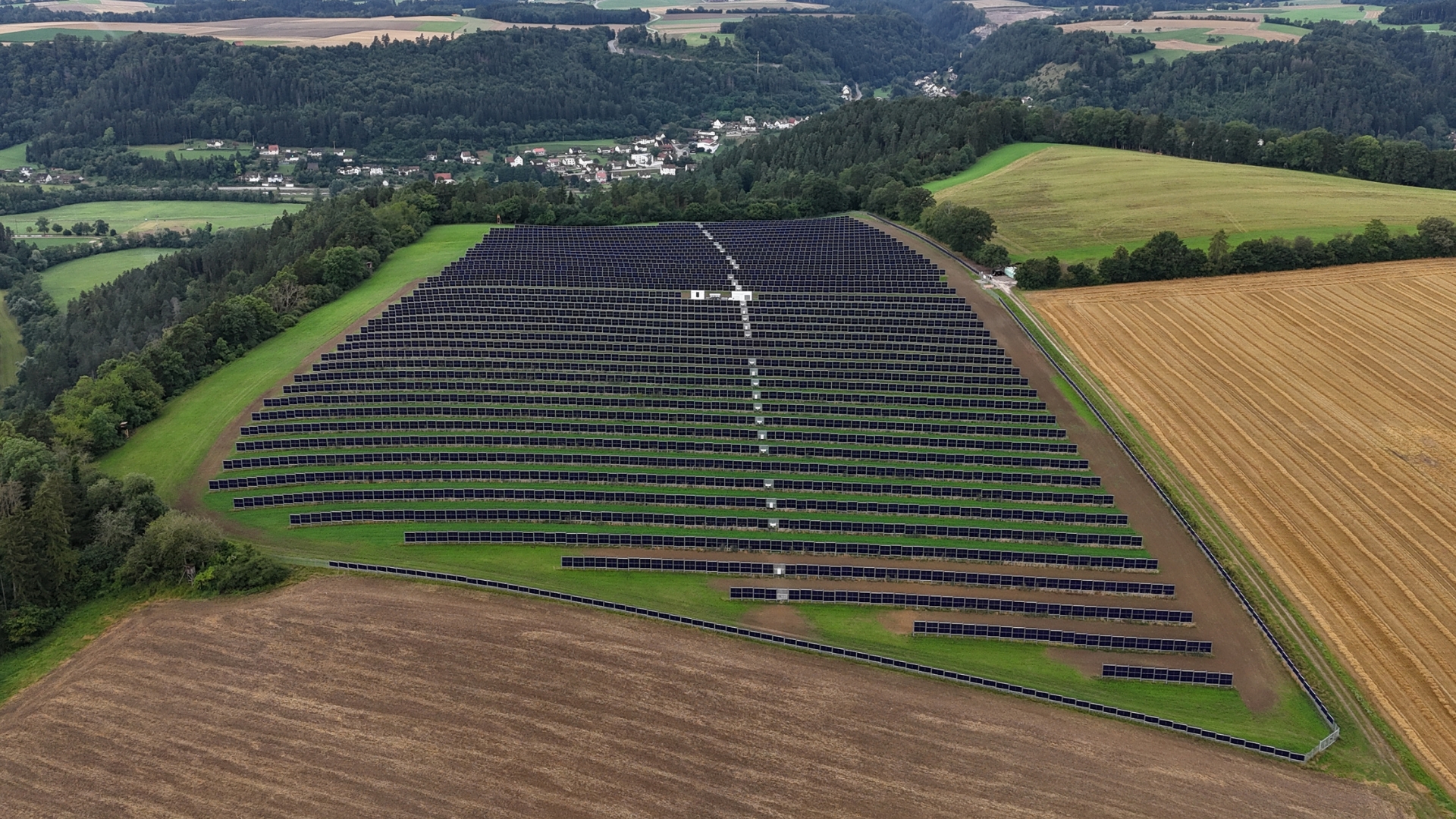 Industrial scale vertical bifacial solar panels installed in rows on a utility-scale site.