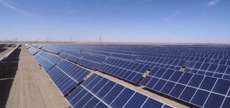 A massive utility-scale solar farm in the Egyptian desert with battery storage containers.