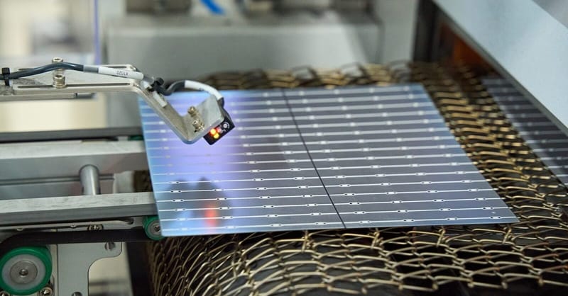 A massive modern solar cell manufacturing floor with automated robotic arms and silicon wafers.