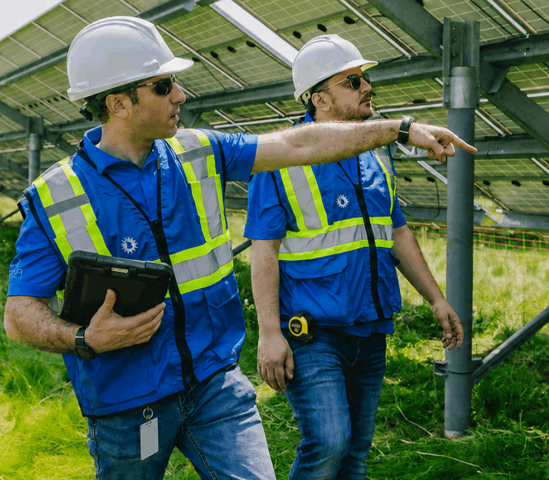 A solar technician performing maintenance on a large-scale commercial PV array.