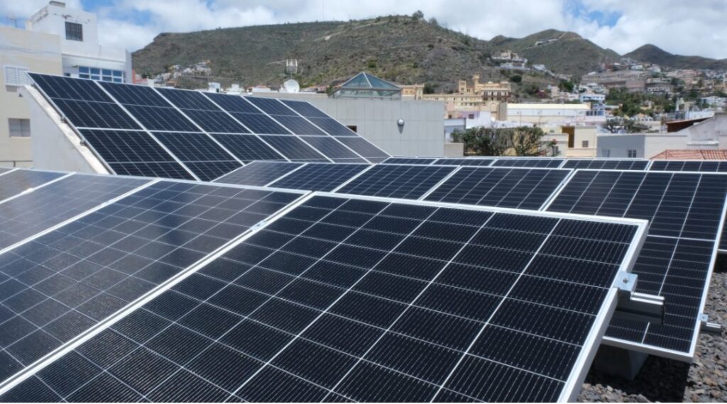A modern solar farm integrated with wind turbines on a sunny European landscape.
