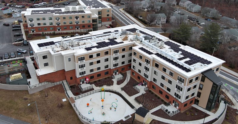 A solar panel array installed on the roof of a community center building