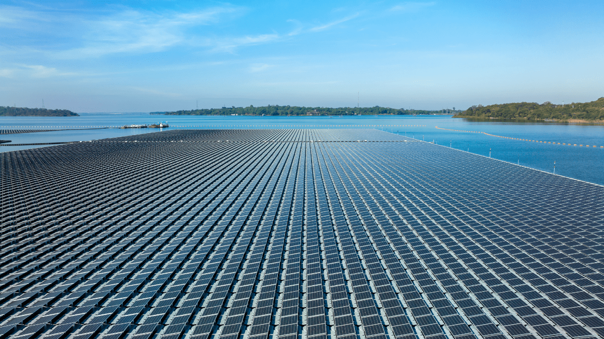 Large scale floating solar array installed on a deep blue mountain reservoir with steep banks