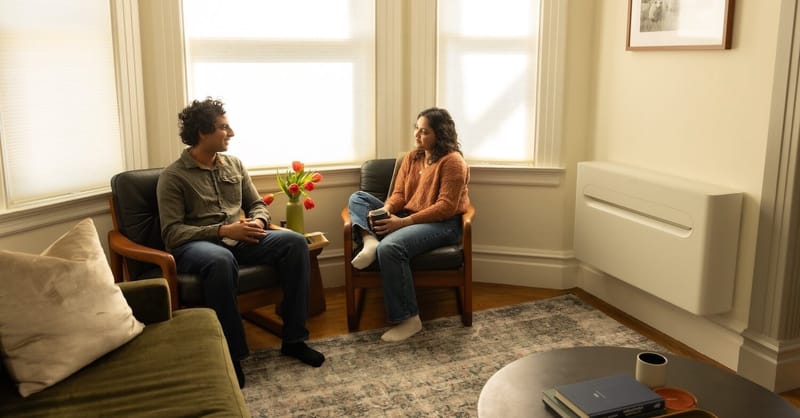 A modern, compact heat pump unit installed in a residential home setting.