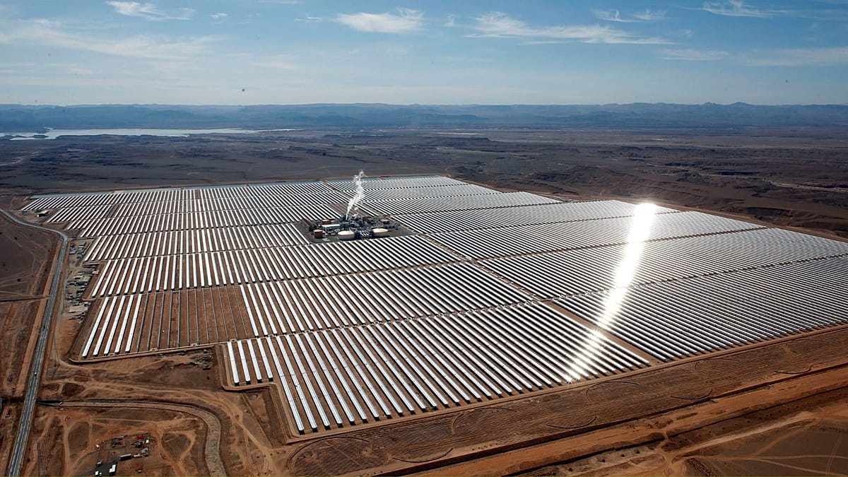 Aerial view of a massive solar farm in an African desert landscape with modern panels