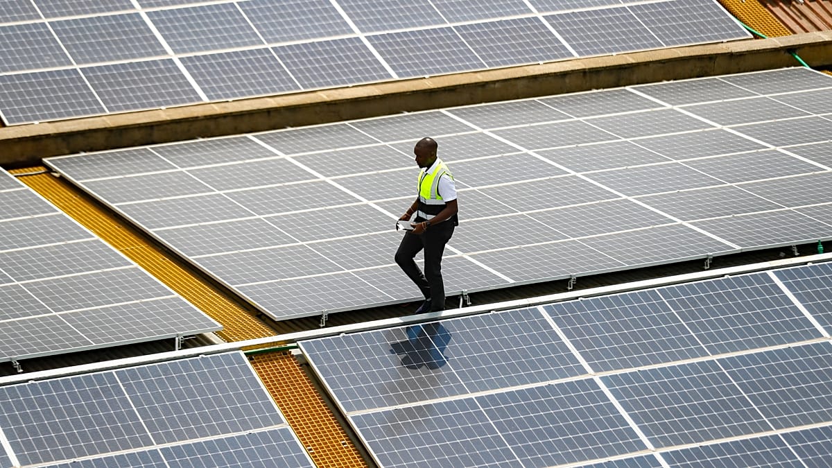 Workers installing high-efficiency solar panels on a European residential rooftop project at sunset