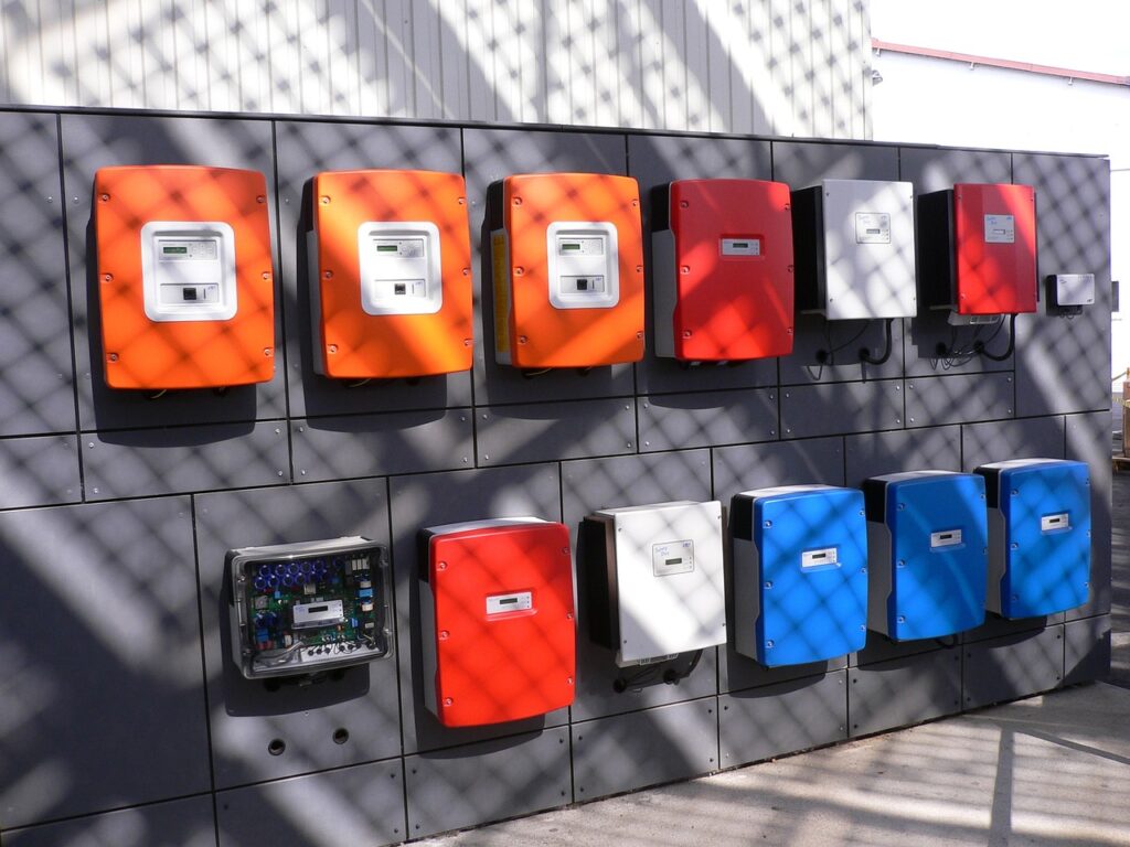 Row of commercial solar inverters on a wall with European flag colors in the background