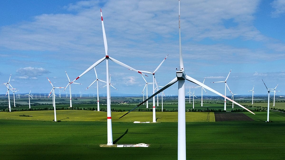 A modern European home with rooftop solar panels and a battery storage system installed.