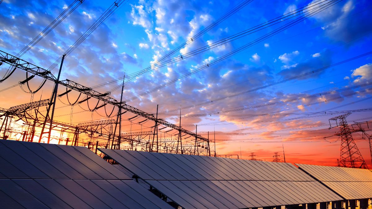 Aerial view of a solar mini-grid installation in a rural landscape with battery storage containers.