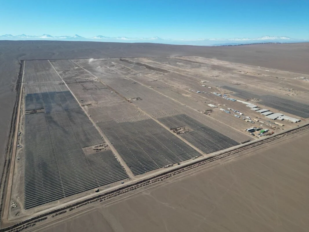 Large scale solar farm with battery storage containers under a clear sky