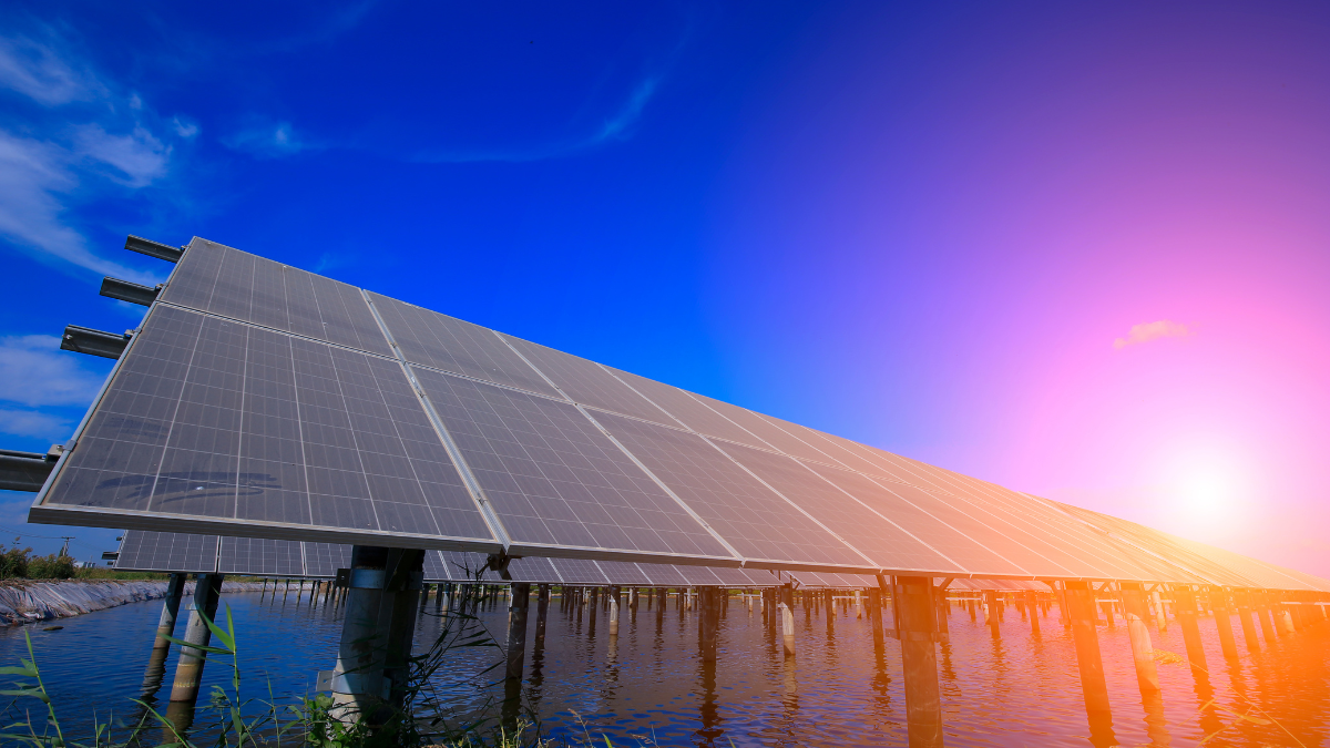 Large commercial rooftop solar array on a flat industrial roof with silver panels.