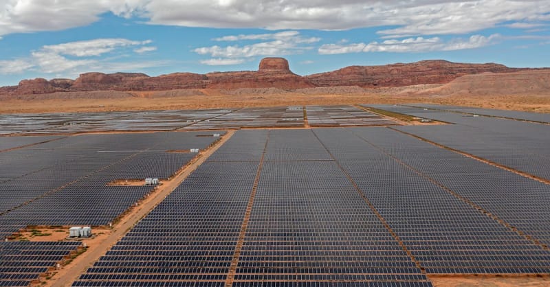 A residential rooftop solar array with a battery storage unit in a suburban setting.