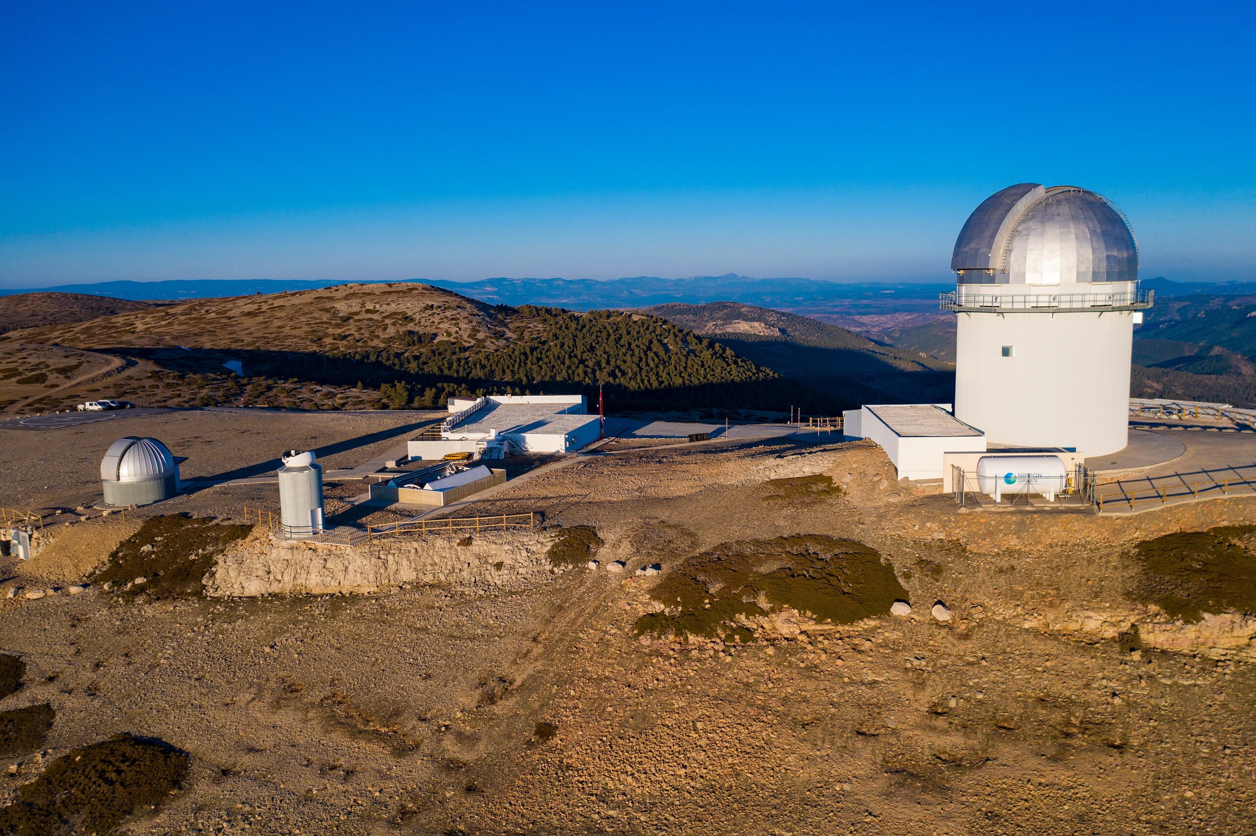 Aerial view of a mountain peak observatory with potential for solar panel installation