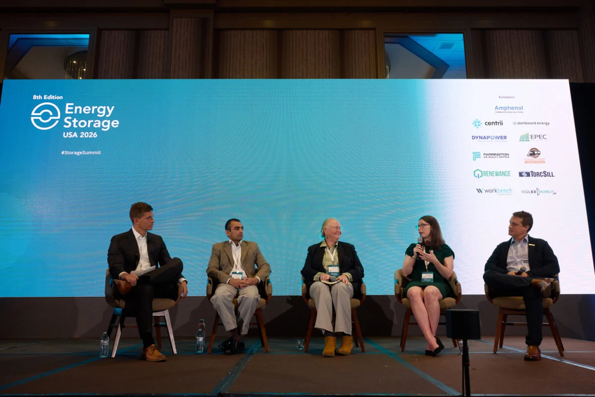 A technician inspecting a lithium battery rack inside a containerized BESS installation.
