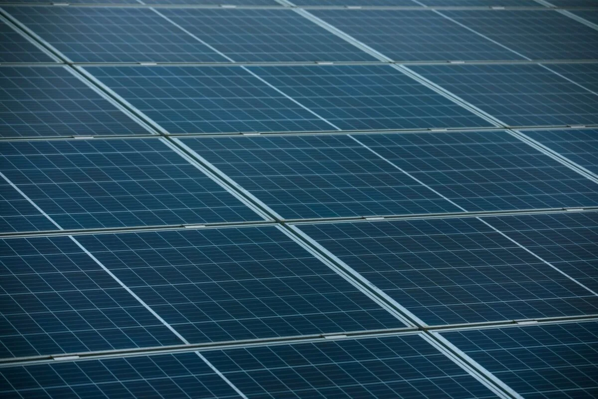 A massive stack of shipping containers and solar modules at a busy European port.