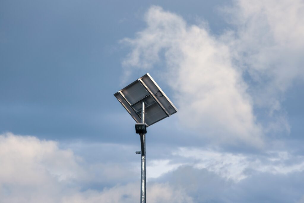 A row of modern solar streetlights under a bright blue sky in a Spanish municipality.