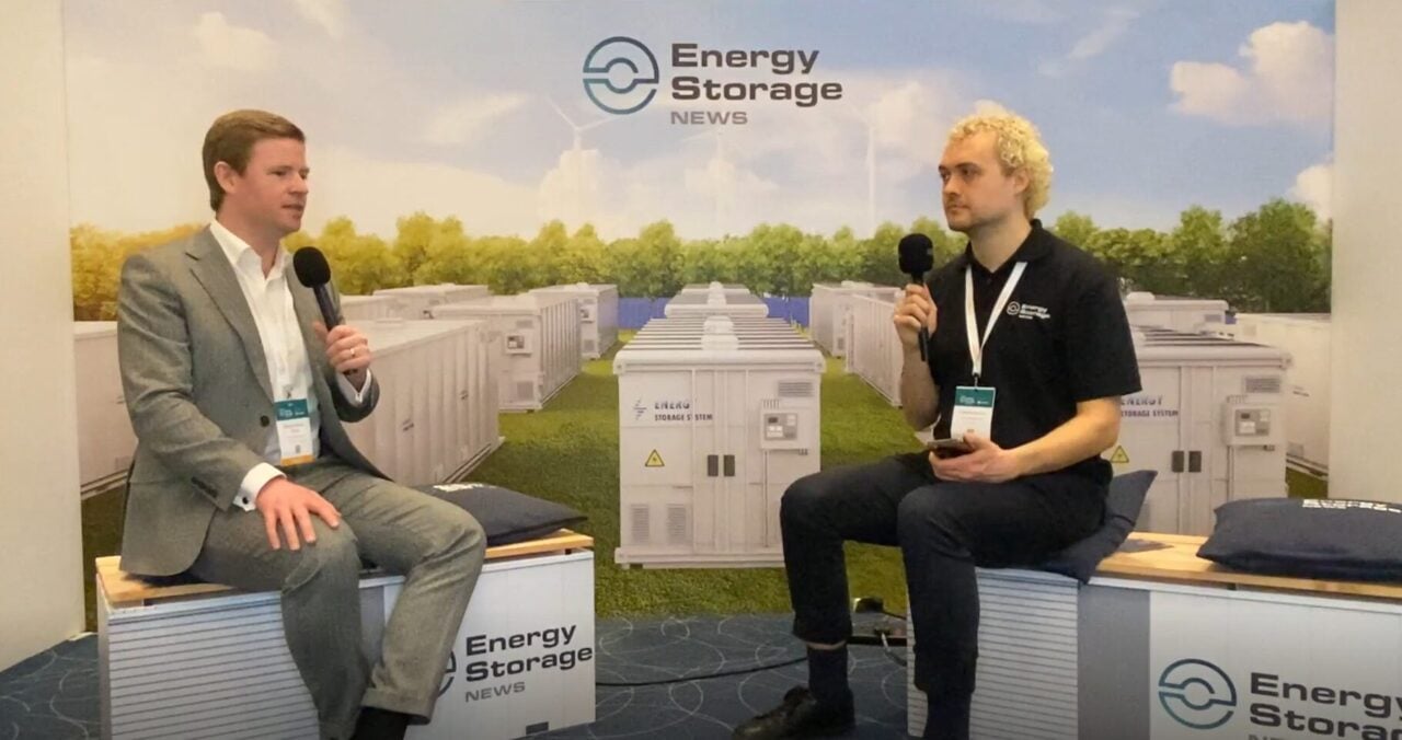 A technician monitoring battery energy storage system data on a digital tablet screen.