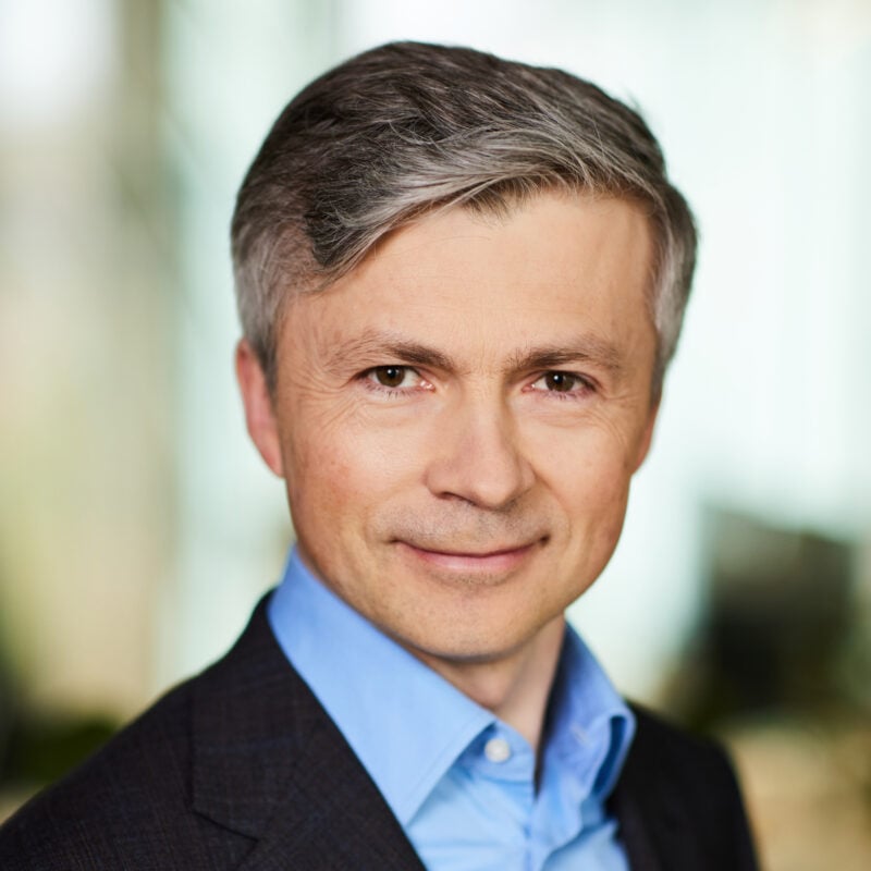 Solar panels in a German field with wind turbines in the background