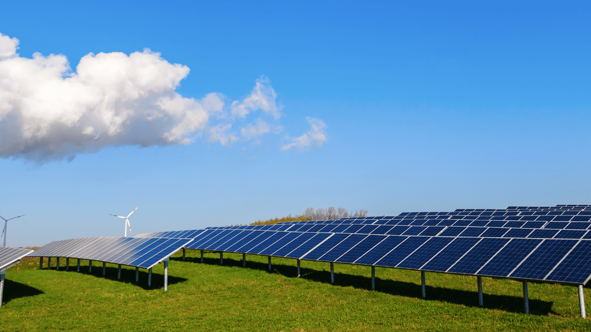 Aerial view of a massive utility-scale solar installation on flat industrial terrain.