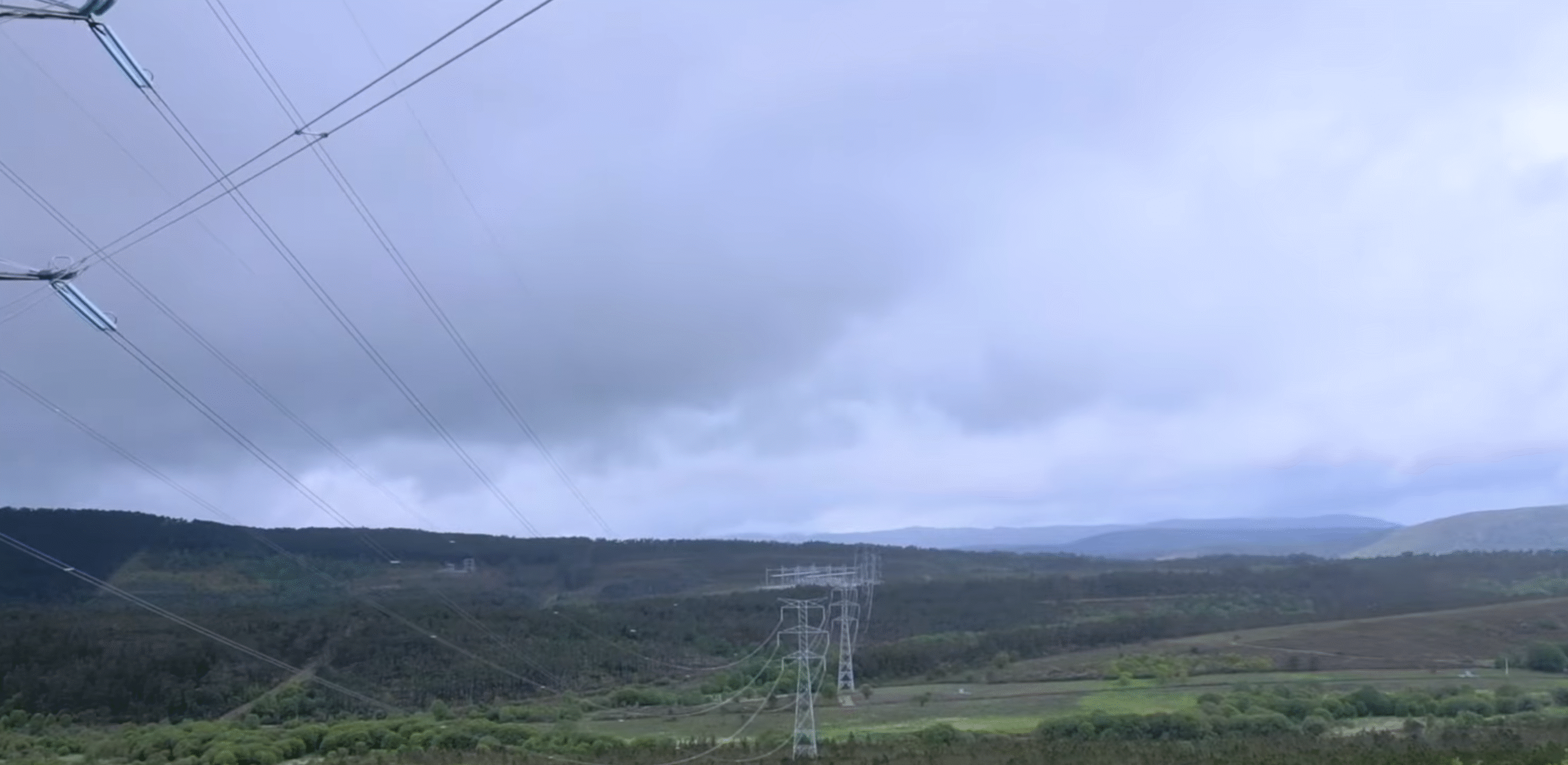 High-voltage 400 kV transmission towers crossing the Spanish-Portuguese border landscape