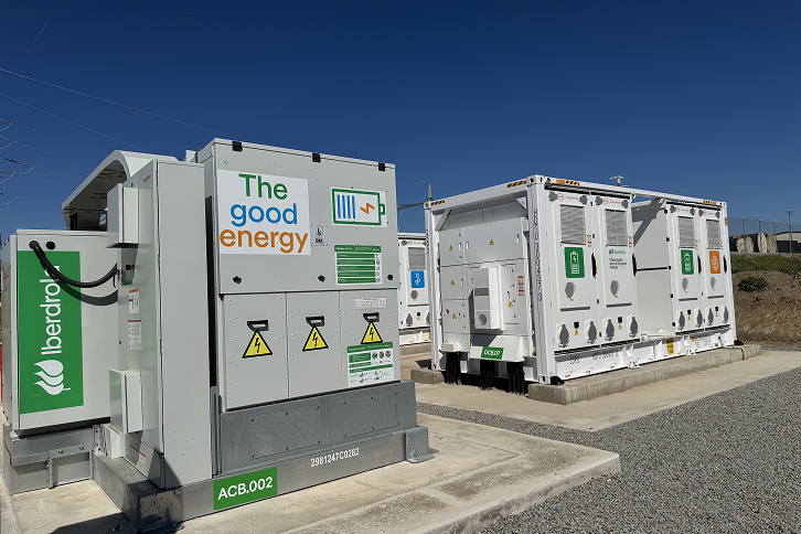 A utility-scale solar farm with integrated battery storage containers in the Spanish countryside.