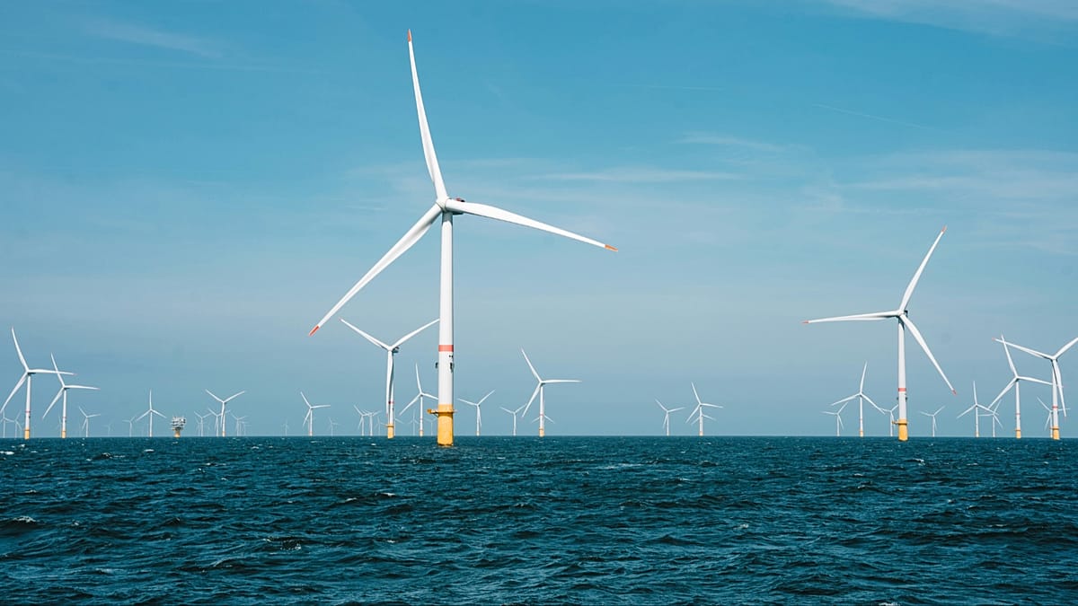 Offshore wind turbines standing in the North Sea under a cloudy sky.