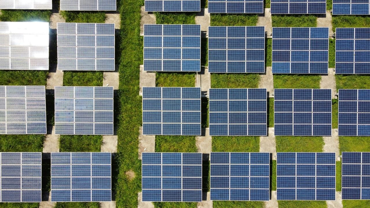 Aerial view of a large scale solar farm with modular containerized battery energy storage systems