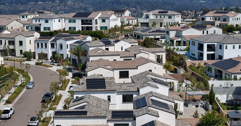 A row of residential battery storage units installed in a modern European garage