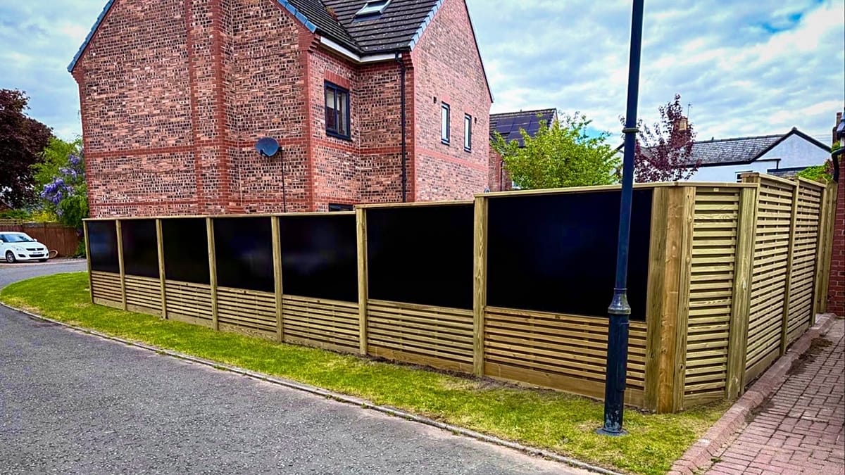 Vertical bifacial solar panels installed as a garden fence in a residential backyard