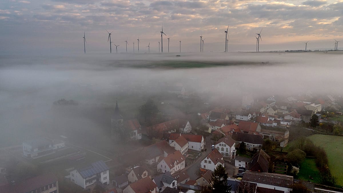 Aerial view of a massive solar farm next to a decommissioned coal power plant chimney
