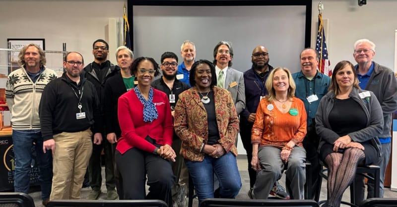 A community group meeting in a neighborhood setting discussing rooftop solar panel installation options.