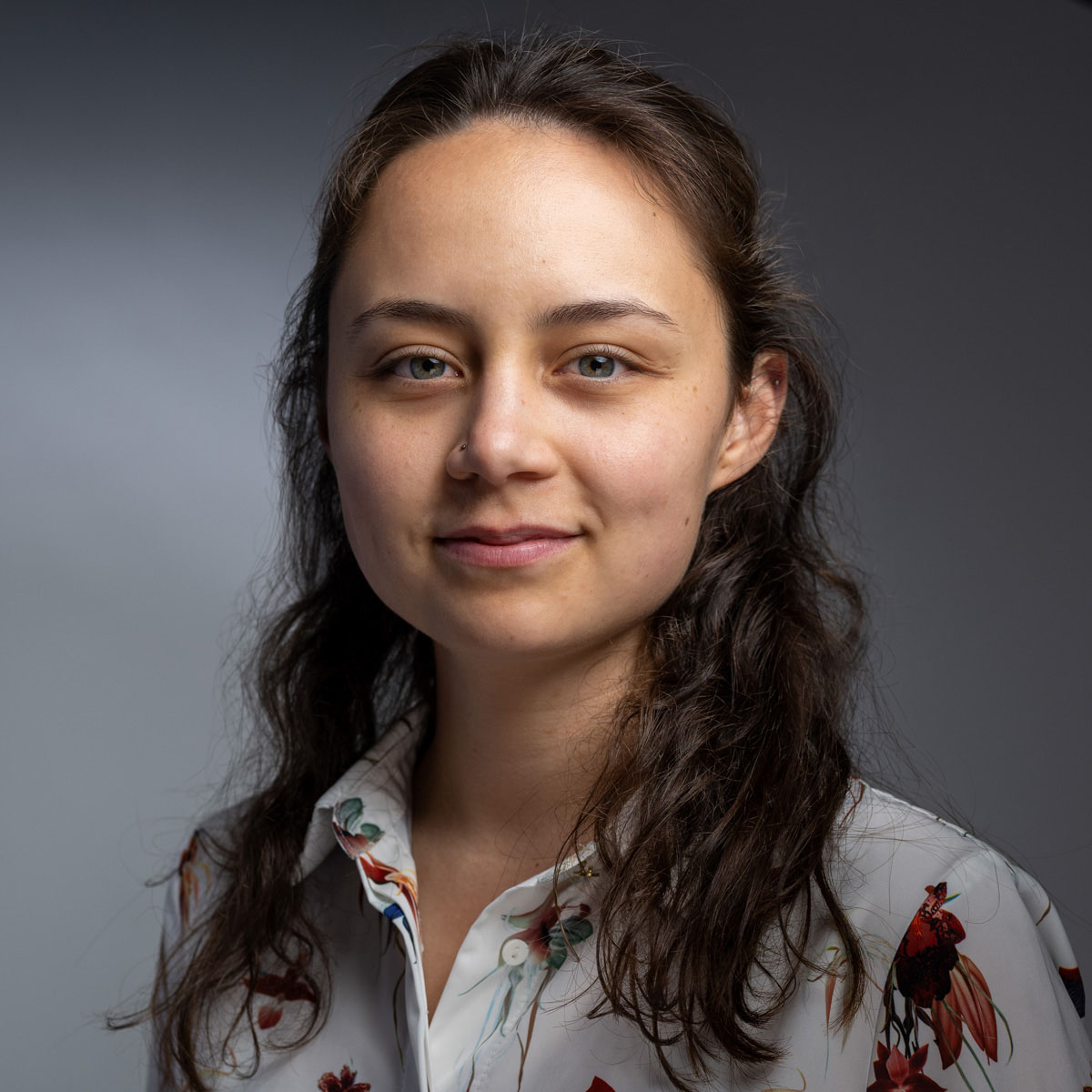 A European Union flag waving in front of a modern wind turbine and solar panels.
