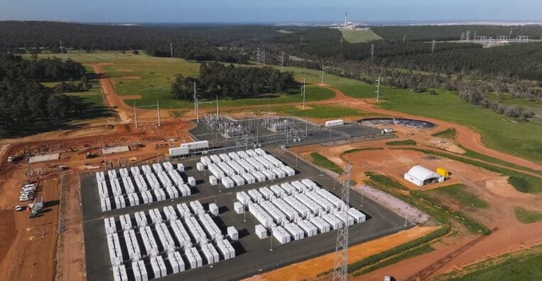 Aerial view of a wind and solar hybrid farm with large battery storage containers.