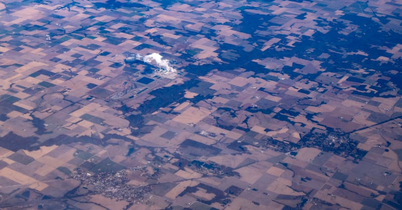 Large coal power plant cooling towers with a foreground of a modern solar farm