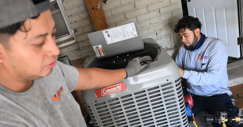 A modern heat pump unit installed next to a residential solar inverter system