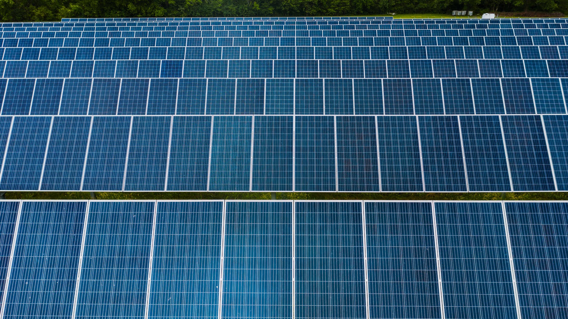 Rows of utility-scale solar panels in a large open field power station