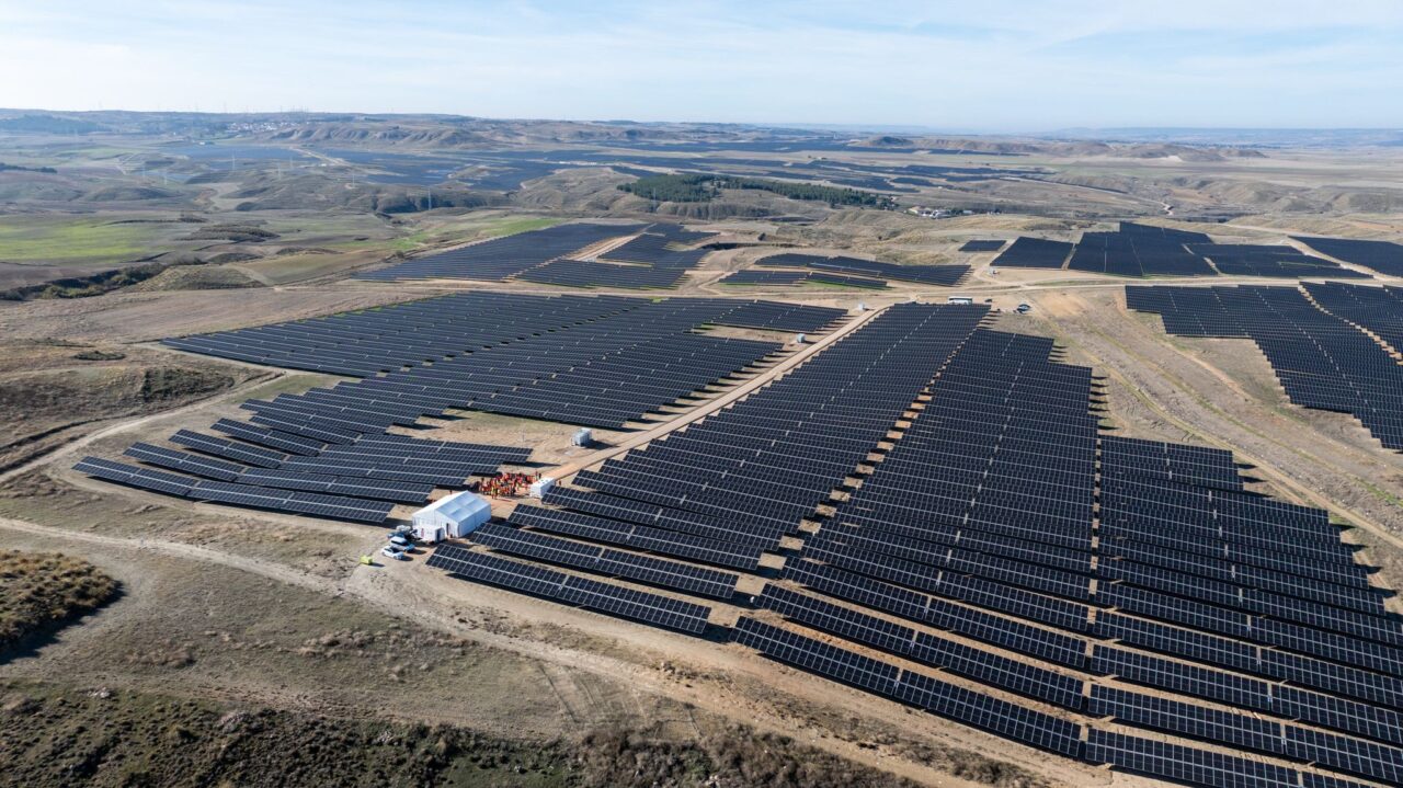 Aerial view of a large-scale solar farm in rural Spain under a bright sun