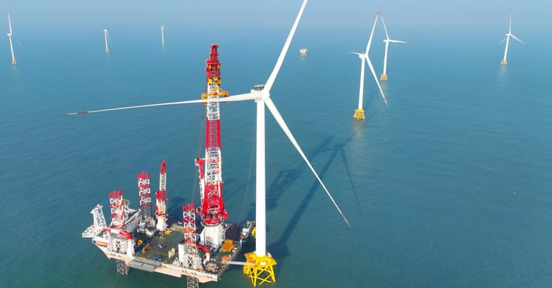 A row of utility-scale solar panels in a field under a clear blue sky