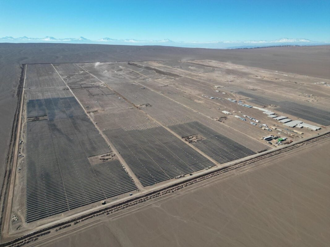 Aerial view of a massive solar-plus-storage field in a desert landscape