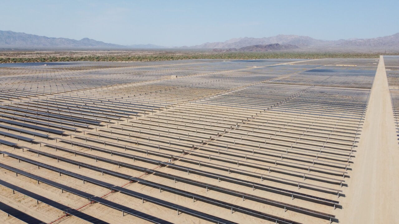 Aerial view of a massive utility-scale solar farm in a desert environment