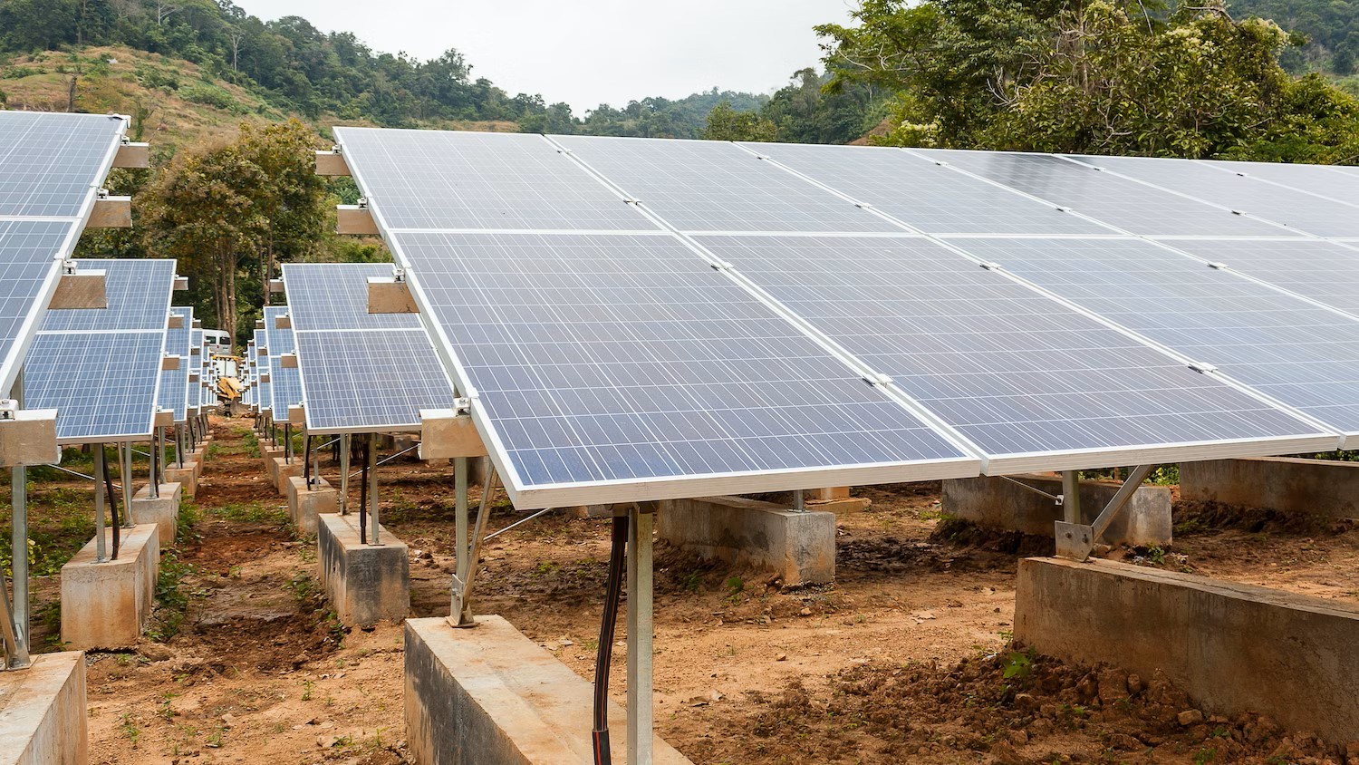 Aerial view of a solar mini-grid installation in a remote African landscape with battery storage containers.